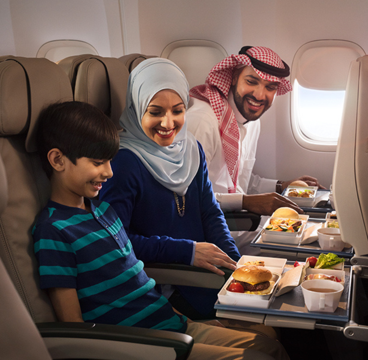 Black woman smiling looking at the horizon to the left. She wears a white blouse. She has curly hair and a very striking smile.